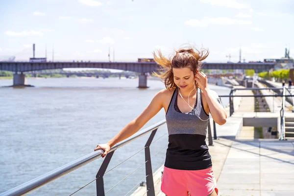 Sporty woman listening music before running. Female athlete list — Stock Photo, Image