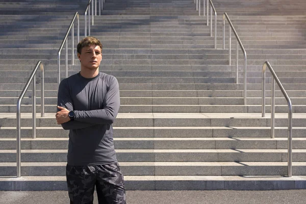 Jonge man in sportkleding in stedelijke plaats staande rusten na ex — Stockfoto