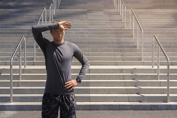 Genç adam kentsel ayakta dinlenme içinde spor giyim, sonra eski