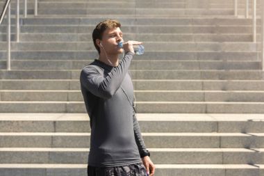 Adam içme suyu kentsel arka planda çalıştırdıktan sonra uygun. Genç 