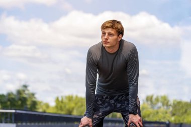 Genç adam güneşli egzersiz sonra ile clo üzerinde gökyüzü dinlenme