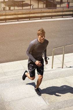 Erkek atlet bir merdivenin koşu hızı ile eğitim veya açık havada merdivenlerden, koşu sırasında çalışma sportif tişört sportif genç adam flare güneş