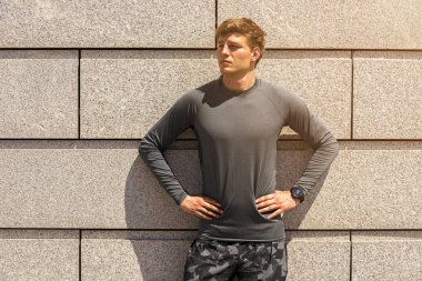 Kas yapı genç atlet, yorgun açık havada, atletik jogger parlak spor giyim güzel beton duvar arka planda, fitness kavramı çalıştırdıktan sonra dinlenme içinde eğitim sonra