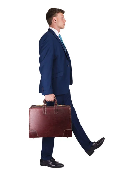 Бизнесмен в прекрасном костюме держит в одной руке чемодан, ходит т — стоковое фото