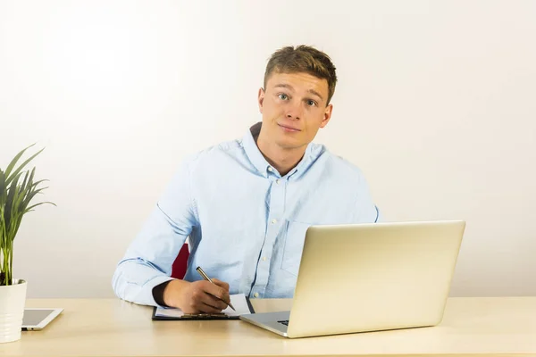 Retrato de un joven guapo sonriente usando computadora portátil b — Foto de Stock