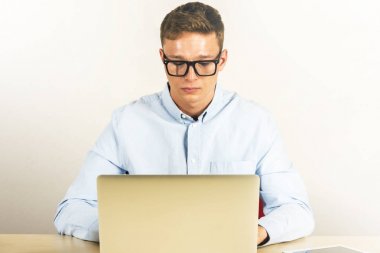 Dizüstü bilgisayar kullanarak Office onun masasında oturan genç adam portresi