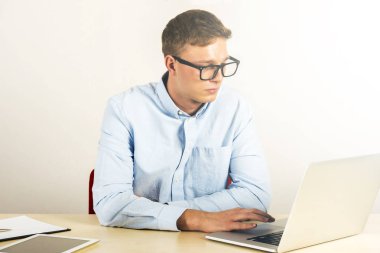 Dizüstü bilgisayar kullanarak Office onun masasında oturan genç adam portresi
