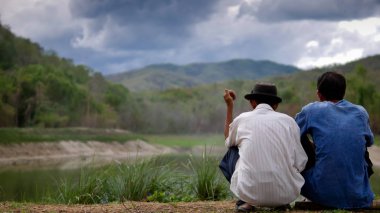 İki adam göl ve orman hakkında konuşun. 
