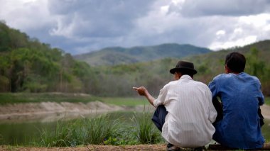 İki adam göl ve orman hakkında konuşun. 