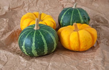 Kağıt zemin üzerinde sonbahar portakalı ve yeşil kabaklar