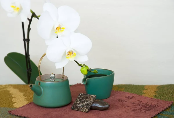 Zátiší Konvicí Kouskem Puer Čaje Bílou Orchidejí — Stock fotografie