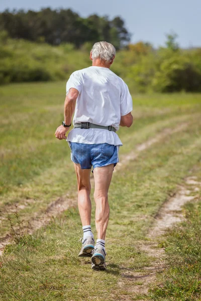 Coureur senior en course sur le terrain — Photo