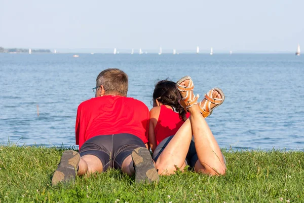 Joven pareja alegre se superpone a la orilla del lago — Foto de Stock