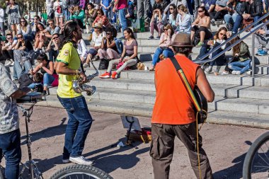 Sokak müzisyenleri için dinleme merdivenlerde oturan insanlar