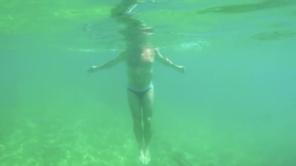 Joven hacer gimnasia de agua en el agua transparente en la Costa Brava en España — Vídeos de Stock