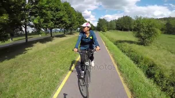 Chica joven ir con bicicleta en una carretera en bicicleta en Hungría — Vídeos de Stock