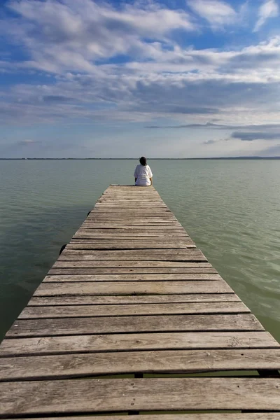Jong meisje op de houten pier — Stockfoto