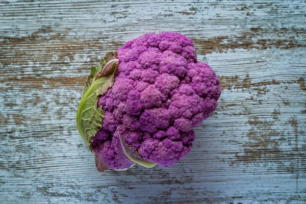 Paarse kleur bloemkool groente op een grijze tafel — Stockfoto