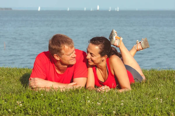Young couple lies on the shore in lake Balaton in Hungary — Stock Photo, Image