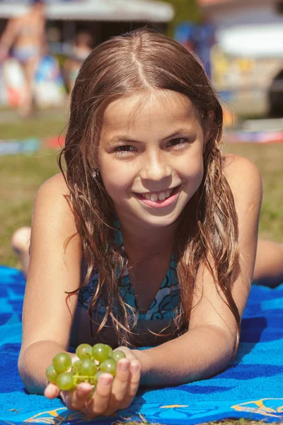 Linda chica joven en la playa con uva — Foto de Stock