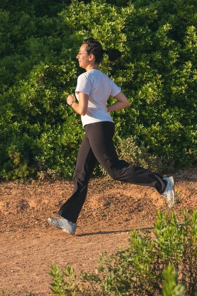 Genç kız atlet orman yolu üzerinde Bahar üzerinde — Stok fotoğraf