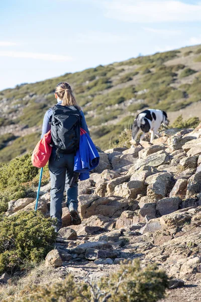 Donna bionda trekking sulla montagna spagnola Montseny con un cane — Foto Stock