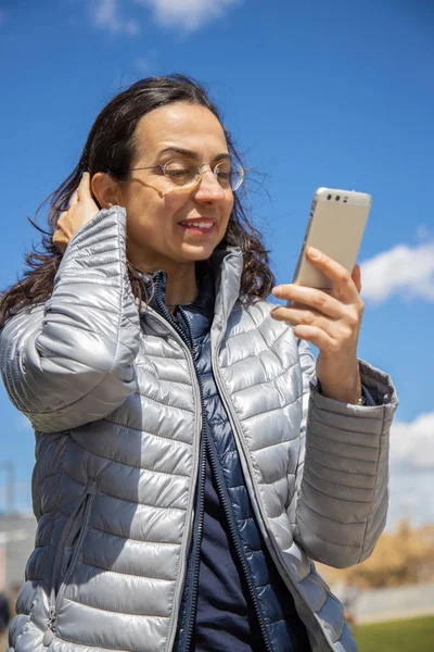 屋外で晴れた日にモバイルとかなりヒスパニック系の女性 — ストック写真