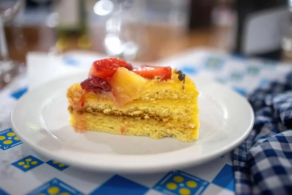 Rebanada de delicioso pastel de frutas en un plato blanco — Foto de Stock