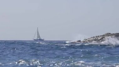 İspanyol Costa Brava 'nın güzel deniz manzarası Katalonya' da, uzaklarda bir yelkenli.