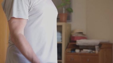 Atletik adam evde tek elli halterle egzersiz yapar.