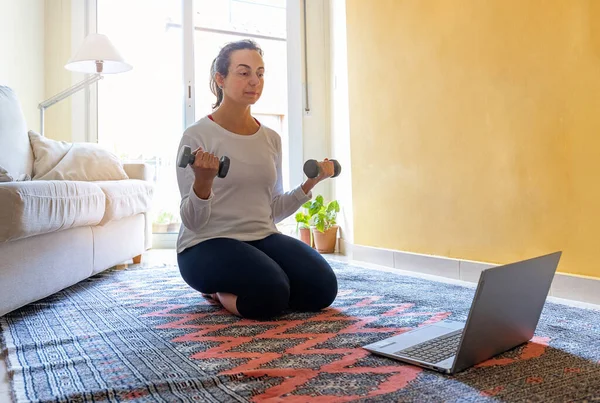스페인어를 구사하는 여자가 노트북으로 온라인 강좌를 있습니다 거실에서 쓰레기 훈련을 — 스톡 사진