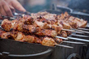 Baharat Marine, parçalar halinde kesilmiş ve kömürün üstünde kavrulmuş bir şiş domuz koymak. Izgara ve barbekü et ürünleri hazırlanması.