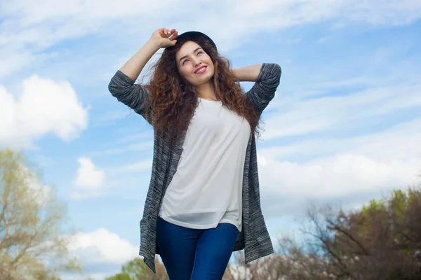 Menina atraente, jovem em jeans e um chapéu preto — Fotografia de Stock