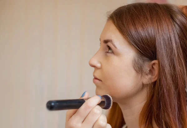 Maskérka použít profesionální štětec na make-up v salonu krásy. — Stock fotografie