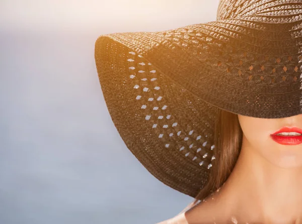 Menina atraente em um chapéu preto usado na cabeça, na praia . — Fotografia de Stock