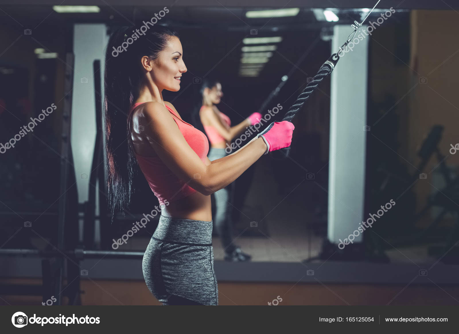 Slim, bodybuilder girl, does the exercises standing in front of