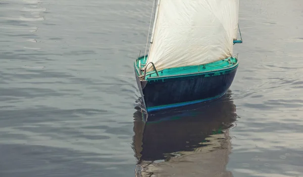 Barco con velas blancas flotando en el agua — Foto de Stock