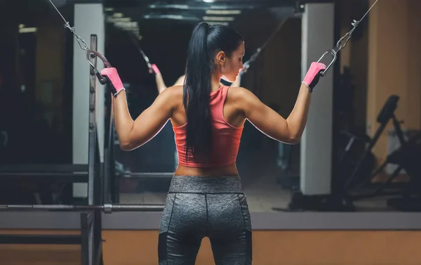 İnce, vücut geliştirmeci kızın, yaptığı spor salonunda ayna önünde duran egzersizleri
