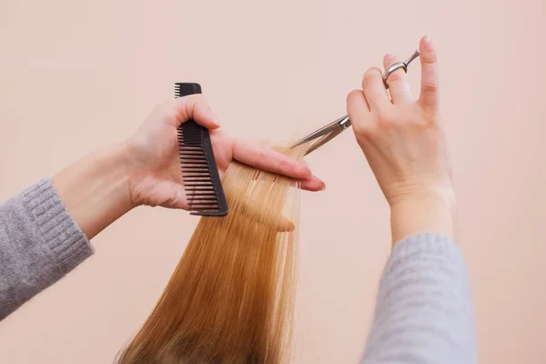 Парикмахер делает стрижку с ножницами волос молодой девушке , — стоковое фото