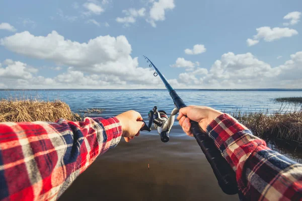 El pescador atrapa peces en la orilla del lago, sostiene sus manos girando — Foto de Stock