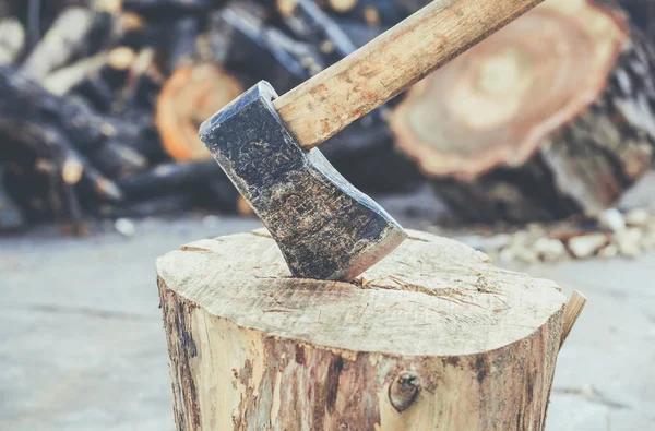 Velho, desgastado, arranhado, machado afiado em pé sobre uma árvore rachada de madeira — Fotografia de Stock