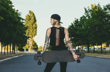 Dövme standları bir longboard ile mavi saçlı bir hippi güzel, seksi sarışın 