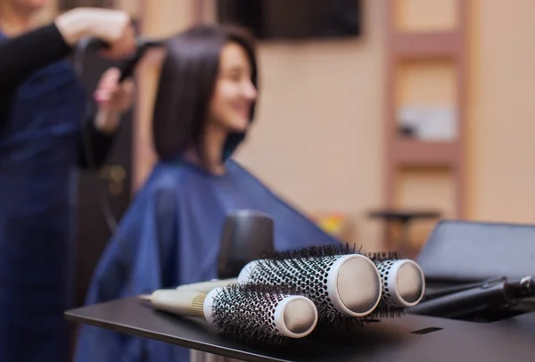 De kapper droogt haar haar een brunette meisje in een schoonheidssalon — Stockfoto