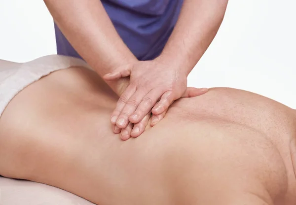 De masseur maakt een massage op de achterkant van de patiënt — Stockfoto