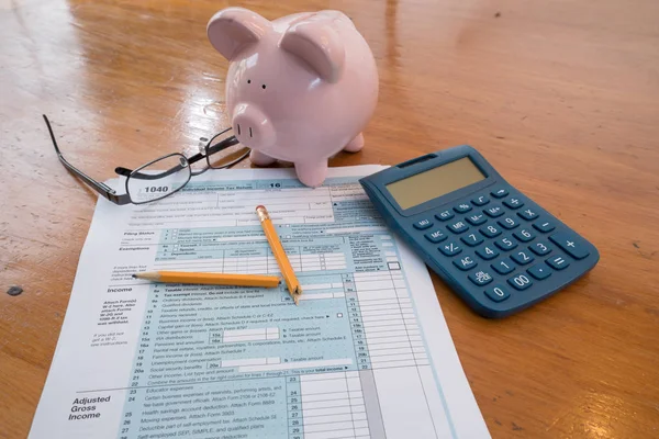 IRS belastingformulier met spaarvarken en rekenmachine gebroken potlood — Stockfoto