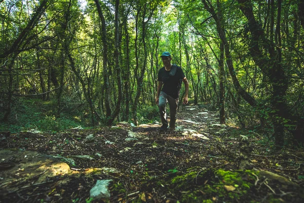 Homem Com Uma Mochila Sobe Uma Estrada Montanha Uma Floresta — Fotografia de Stock