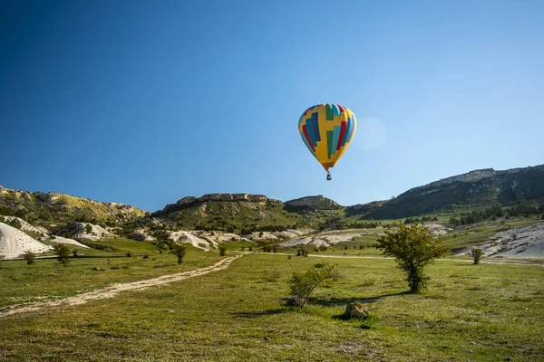 Ένα Αερόστατο Πετά Πάνω Από Έδαφος Έναν Γαλάζιο Ουρανό Σύννεφα — Φωτογραφία Αρχείου