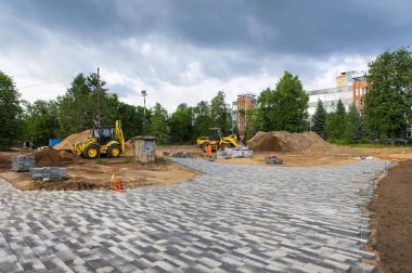 İnşaat ekipmanları yaz aylarında parka yeni döşemeler döşemek için zemini düzleştiriyor