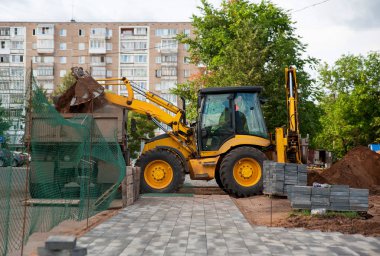İnşaat ekipmanları yaz aylarında parka yeni döşemeler döşemek için zemini düzleştiriyor
