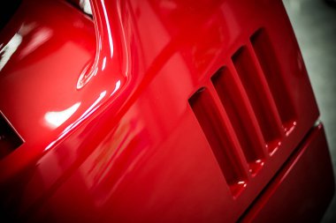 Kırmızı, modern bir yarış arabasının vücut öğeleri. Kapalı ve bulanık arka plan.